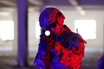 Image showing A professional soldier undertakes a perilous mission in an abandoned building illuminated by neon blue and purple lights