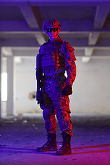 Image showing A professional soldier undertakes a perilous mission in an abandoned building illuminated by neon blue and purple lights