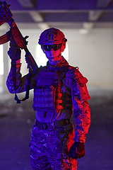 Image showing A professional soldier undertakes a perilous mission in an abandoned building illuminated by neon blue and purple lights