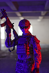 Image showing A professional soldier undertakes a perilous mission in an abandoned building illuminated by neon blue and purple lights