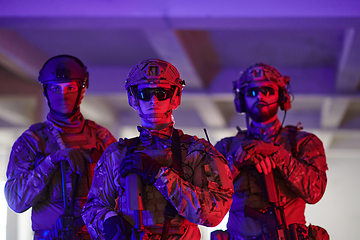 Image showing Soldier squad team walking in urban environment colored lightis