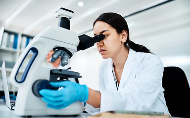 Image showing Clinical research and trials are fundamental tools of modern medicine. a young scientist using a microscope in a lab.