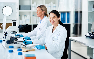 Image showing Science really holds so many answers about the world. Portrait of a young scientist working in a lab with her colleague in the background.