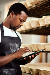 Image showing Freshness is my promise to all my customers. a man using a digital tablet while working in a bakery.