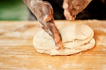 Image showing It takes skill to make the best. a male baker busy shaping dough at work.