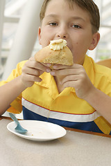 Image showing Hungry Appetite:  Child eating a delicious baked muffin