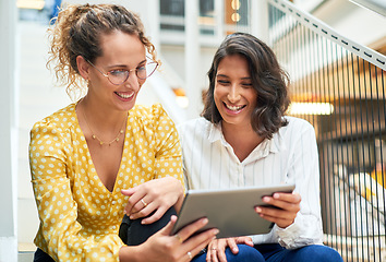 Image showing The better you work together the better the results. two young businesswomen using a digital tablet in a modern office.