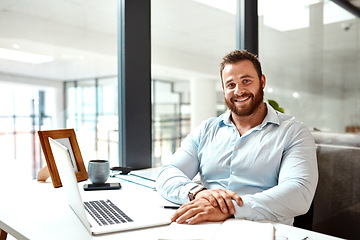 Image showing Im happy with how far Ive come in my career. Portrait of a young businessman sitting at a desk in an office.