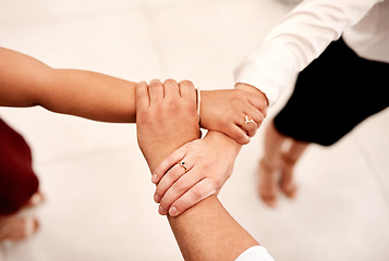 Image showing Inspired to band together and celebrate collaboration. Closeup shot of a group of unrecognisable businesspeople holding on to each others arms.