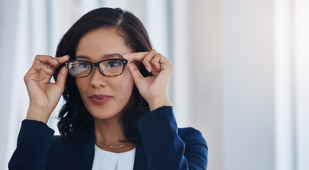 Image showing She holds a strong vision for success. a young businesswoman holding a pair of spectacles in an office.