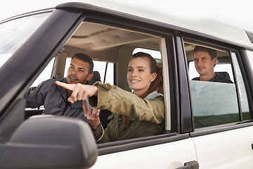 Image showing Theres where we need to be. a young woman shpowign her friend where to go while on a roadtrip.