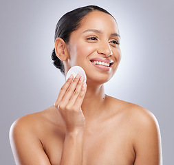 Image showing A good skincare routine is vital. an attractive young woman standing alone in the studio and using a cotton pad on her face.