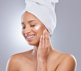 Image showing Maintaining smooth skin is a challenge I enjoy. an attractive young woman applying moisturiser to her skin in the studio.