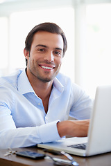 Image showing I believe in the magical powers of hard work. Portrait of a handsome businessman using his laptop in the office.