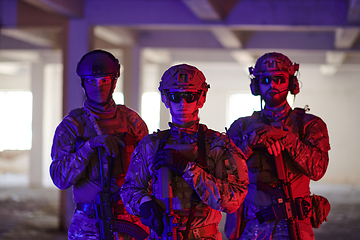 Image showing Soldier squad team walking in urban environment colored lightis