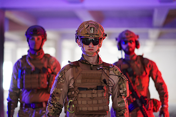 Image showing Soldier squad team walking in urban environment colored lightis