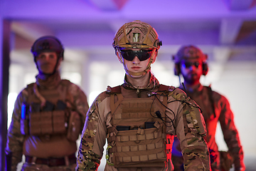 Image showing Soldier squad team walking in urban environment colored lightis