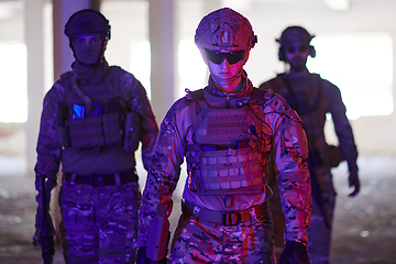 Image showing Soldier squad team walking in urban environment colored lightis