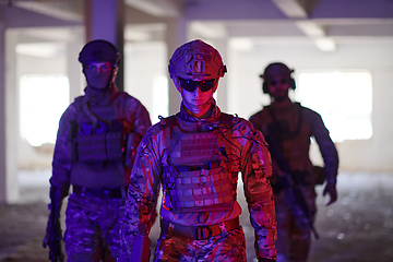 Image showing Soldier squad team walking in urban environment colored lightis