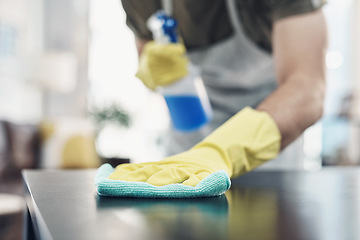 Image showing Bust that dirt with a bit of elbow grease. an unrecognisable man disinfecting a table at home.