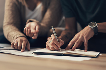 Image showing Managing joint finances is a team effort. a couple going over paperwork at home.