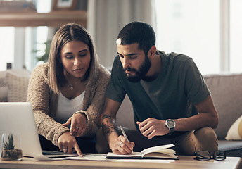 Image showing Setting goals is what super savers do. a young couple using a laptop while going through paperwork at home.