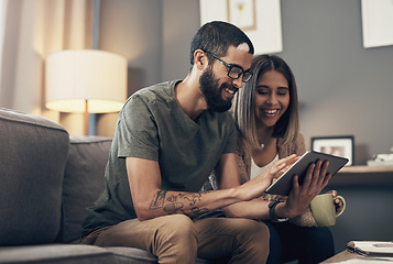 Image showing Meeting financial commitments the smart way. a young couple using a digital tablet on the sofa at home.