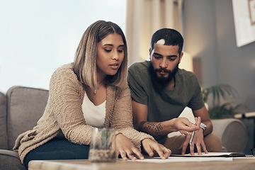 Image showing Make your money grow with smart financial decisions. a young couple going over paperwork at home.