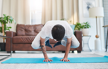 Image showing Yoga transformed me mentally and physically. a handsome young man practising yoga in his living room at home.