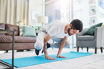 Image showing Keep boredom at bay with a yoga session. a handsome young man practising yoga in his living room at home.
