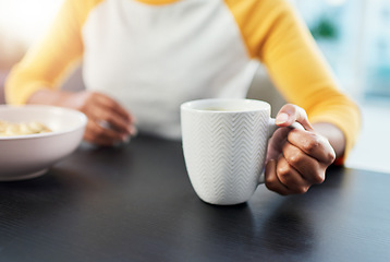 Image showing The day starts after coffee. an unrecognizable woman having her morning coffee at home.