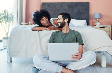 Image showing Want to watch something. a man using his laptop while sitting in the bedroom with his girlfriend.