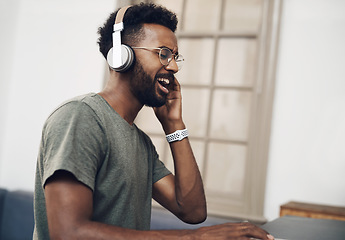 Image showing Jamming to the beat of business. a young businessman using headphones while working in a modern office.