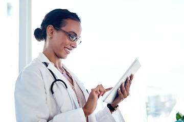 Image showing Tapped into a world of healthcare info. a young doctor using a digital tablet in her consulting room.