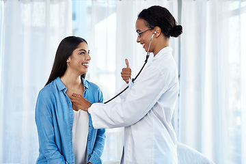 Image showing As strong as a heart should be. a young doctor giving a thumbs up while examining her patient with a stethoscope.