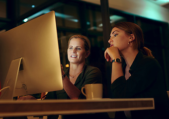 Image showing Lets go over it one last time before shutting down. two businesswoman looking at something on a computer in an office at night.