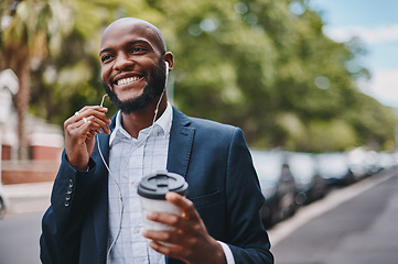 Image showing This break is just what I needed to clear my head. a businessman holding a coffee and listening to music through earphones while walking through the city.