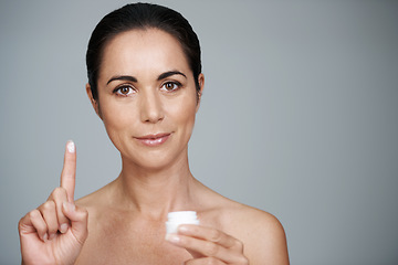 Image showing Stay beautiful for longer. Cropped portrait of a beautiful mid adult woman showing the moisturizer she uses.