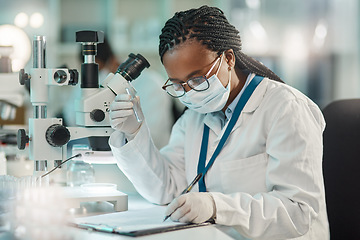 Image showing Gathering information after careful observation. a young scientist writing notes while working in a lab.