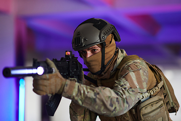 Image showing A professional soldier undertakes a perilous mission in an abandoned building illuminated by neon blue and purple lights