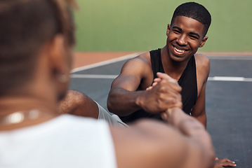 Image showing Good sportsmanship encompasses many aspects of a mans character. two sporty young men shaking hands on a basketball court.