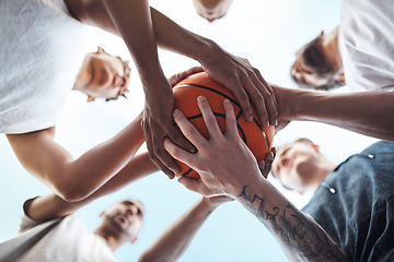 Image showing One team, one dream. Closeup shot of a group of sporty young men huddled around a basketball on a sports court.