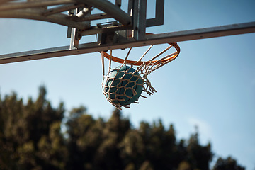 Image showing Shooting hoop and scoring points. Closeup shot of a basketball landing into a net on a sports court.