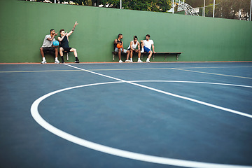 Image showing Its break time. a group of sporty young men sitting on a basketball court.