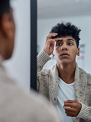 Image showing Dont be afraid to get your brows down. a handsome young man inspecting his face in the bathroom mirror.