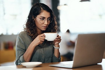 Image showing Where work meets leisure. a young woman using a laptop and having coffee in a cafe.