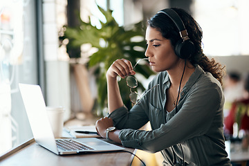 Image showing Its not hard to see why freelancing is so tempting. a young woman using a laptop and headphones in a cafe.