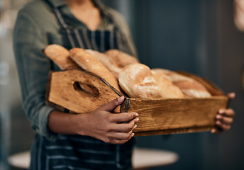 Image showing Were the bread to your gravy. a woman holding a selection of freshly baked breads in her bakery.