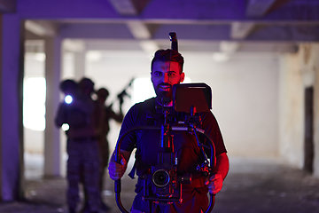 Image showing A professional cameraman captures the intense moments as a group of skilled soldiers embarks on a dangerous mission inside an abandoned building, their actions filled with suspense and bravery