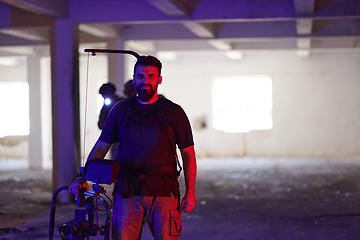 Image showing A professional cameraman captures the intense moments as a group of skilled soldiers embarks on a dangerous mission inside an abandoned building, their actions filled with suspense and bravery